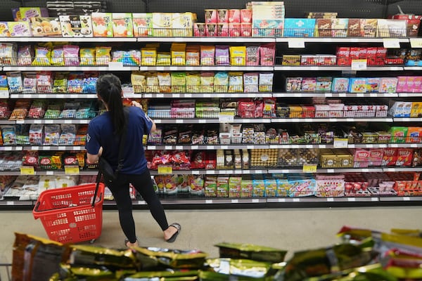 A customer buys Chinese made ginger candy at 99 Ranch Market, an Asian grocery store in Los Angeles Monday, April 7, 2025. (AP Photo/Damian Dovarganes)