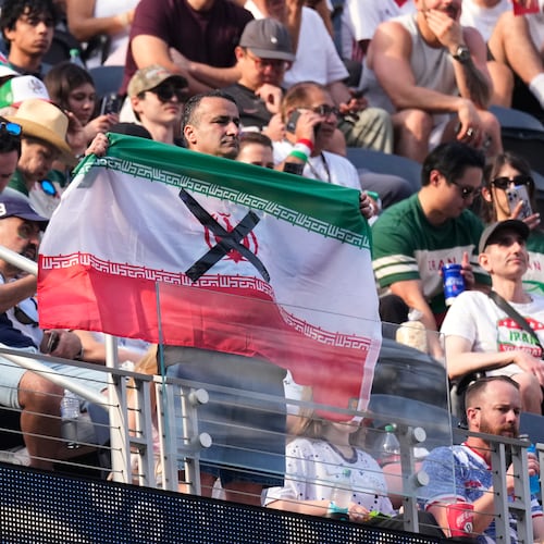 An attendees holds an Iranian flag with an "X" on it before the World Cup Group G soccer match between Iran and New Zealand in Inglewood, Calif., near Los Angeles, Monday, June 15, 2026. (AP Photo/Mark J. Terrill)