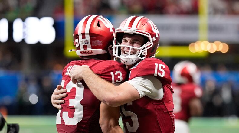 Indiana wide receiver Elijah Sarratt (13) celebrates his touchdown reception with quarterback Fernando Mendoza (15) during the second half of the Peach Bowl NCAA college football playoff semifinal, Friday, Jan. 9, 2026, in Atlanta. (AP Photo/Mike Stewart)