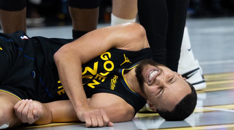 Golden State Warriors guard Stephen Curry lies on the floor during the second half of an Emirates NBA Cup basketball game against the Houston Rockets Wednesday, Nov. 26, 2025, in San Francisco. (AP Photo/Benjamin Fanjoy)
