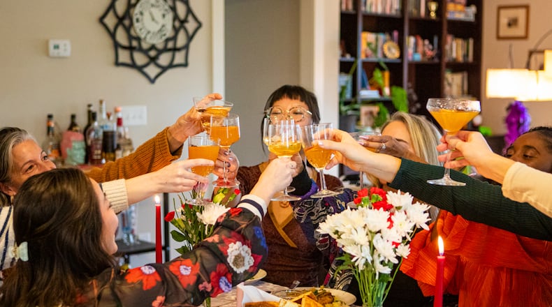 Guests cheer with their Spiced Citrus Gold cocktails at reporter Olivia Wakim's Galentine's Day supper club, featuring recipes from local food and beverage professionals. (Aaliyah Man for The Atlanta Journal-Constitution)