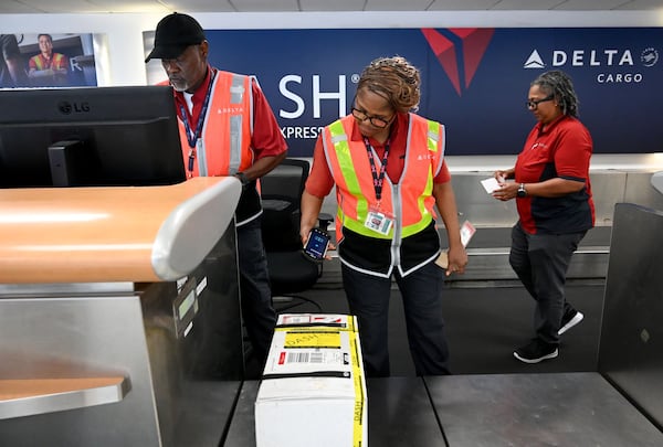 (From left) Kirkland Gibbs, Priscilla Lyons and Doris Minus handle package drop-off for Delta DASH shipping services at Hartsfield-Jackson Atlanta International Airport on Thursday, May 28, 2026. (Hyosub Shin/AJC)