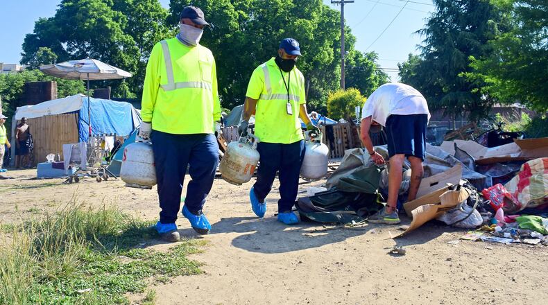 Staff Photo by Robin Rudd / City of Chattanooga Public Works employees remove recyclables and hazardous materials from the East 11th Street homeless camp on June 1, 2022. The City of Chattanooga is preparing to close the East 11th Street homeless camp and clear the property.