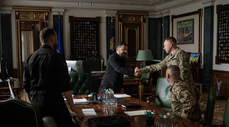 In this photo provided by the Ukrainian Presidential Press Office, Ukrainian President Volodymyr Zelenskyy, center, shakes hands with new commander-in-chief of Ukraine's Armed Forces Mykhailo Drapatyi during their meeting in Kyiv, Ukraine, Monday, July 20, 2026. (Ukrainian Presidential Press Office via AP)