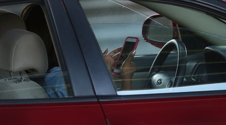 A driver uses a phone while behind the wheel of a car on April 30, 2016 in New York City. (Photo by Spencer Platt/Getty Images)