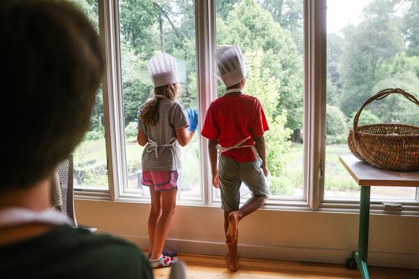Two kids participating in the Wylde Culinary Arts Camp look out the window at the Wylde Center's Oakhurst Garden in Decatur, on Friday, July 24, 2026. (Abbey Cutrer/AJC)