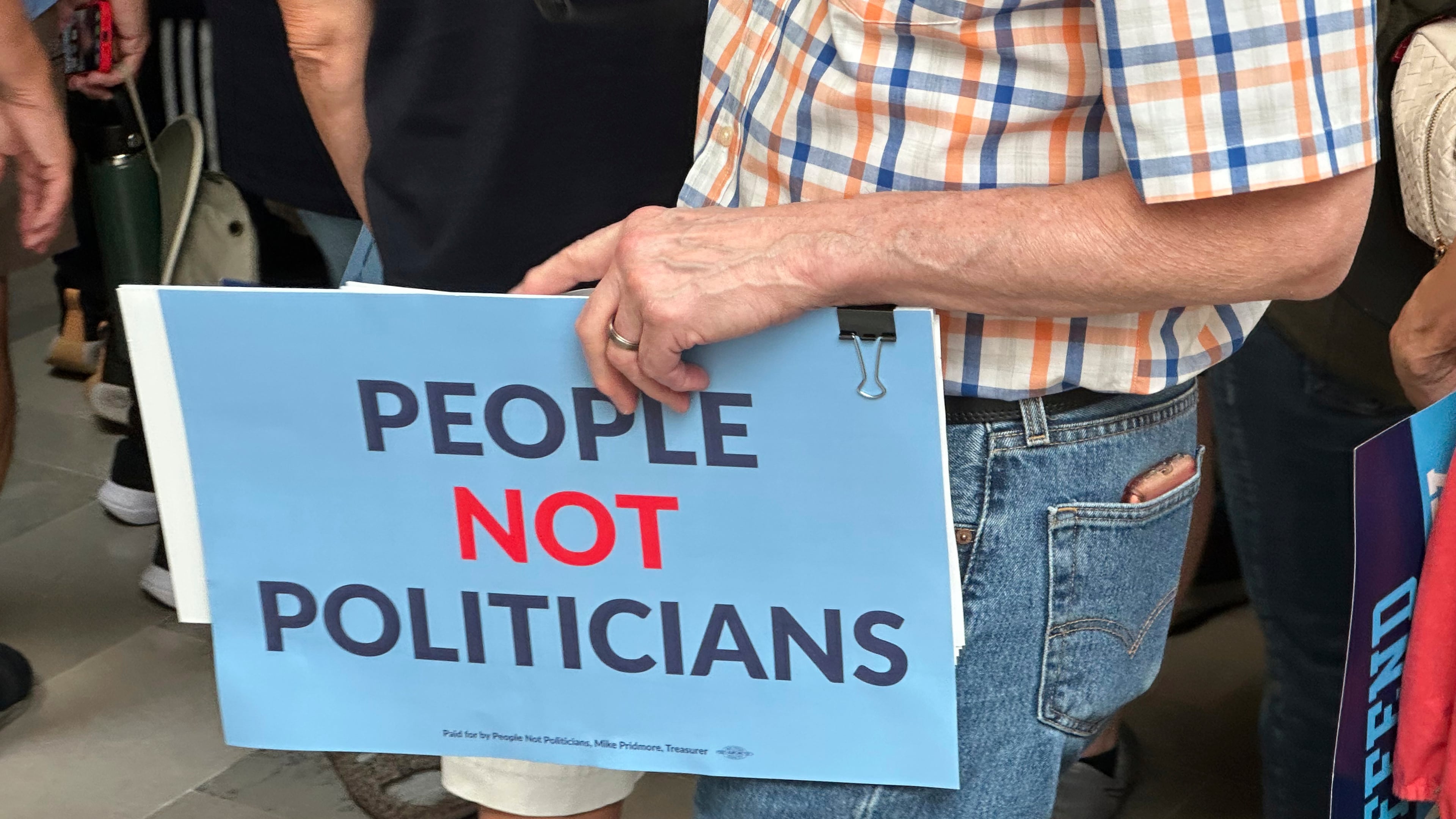 A protestor holds a sign in opposition to a plan redrawing Missouri's U.S. House districts during a rally at the state Capitol, Friday, Sept. 12, 2025, in Jefferson City, Mo. (AP Photo/David A. Lieb)