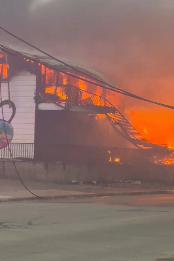 In this photo provided by Evan Bell firefighters combat the wildfires as they consumed Robertson Trading, a general store, in La Ronge, Saskatchewan on June 3, 2025. (Evan Bell via AP)