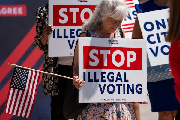 People hold signs reading "Only Citizens Vote" and "Stop Illegal Voting" near the Georgia state Capitol at a rally in Atlanta in August.