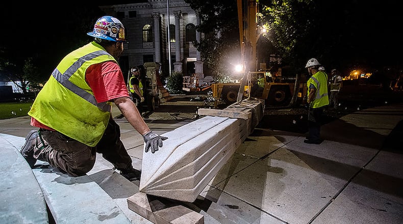 Workers remove a Confederate monument with a crane Thursday, June 18, 2020, in Decatur, Ga. The 30-foot obelisk in Decatur Square, erected by the United Daughters of the Confederacy in 1908, was ordered by a judge to be removed and placed into storage indefinitely.