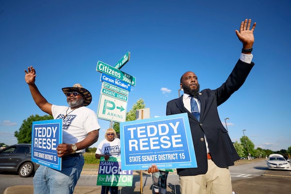 Marquese Averett (right) who is running for Georgia House District 140, campaigns for state Senate candidate Teddy Reese, on a busy Macon Rd and Citizens Way in Columbus, on Wednesday, May 13, 2026. (Miguel Martinez/AJC)