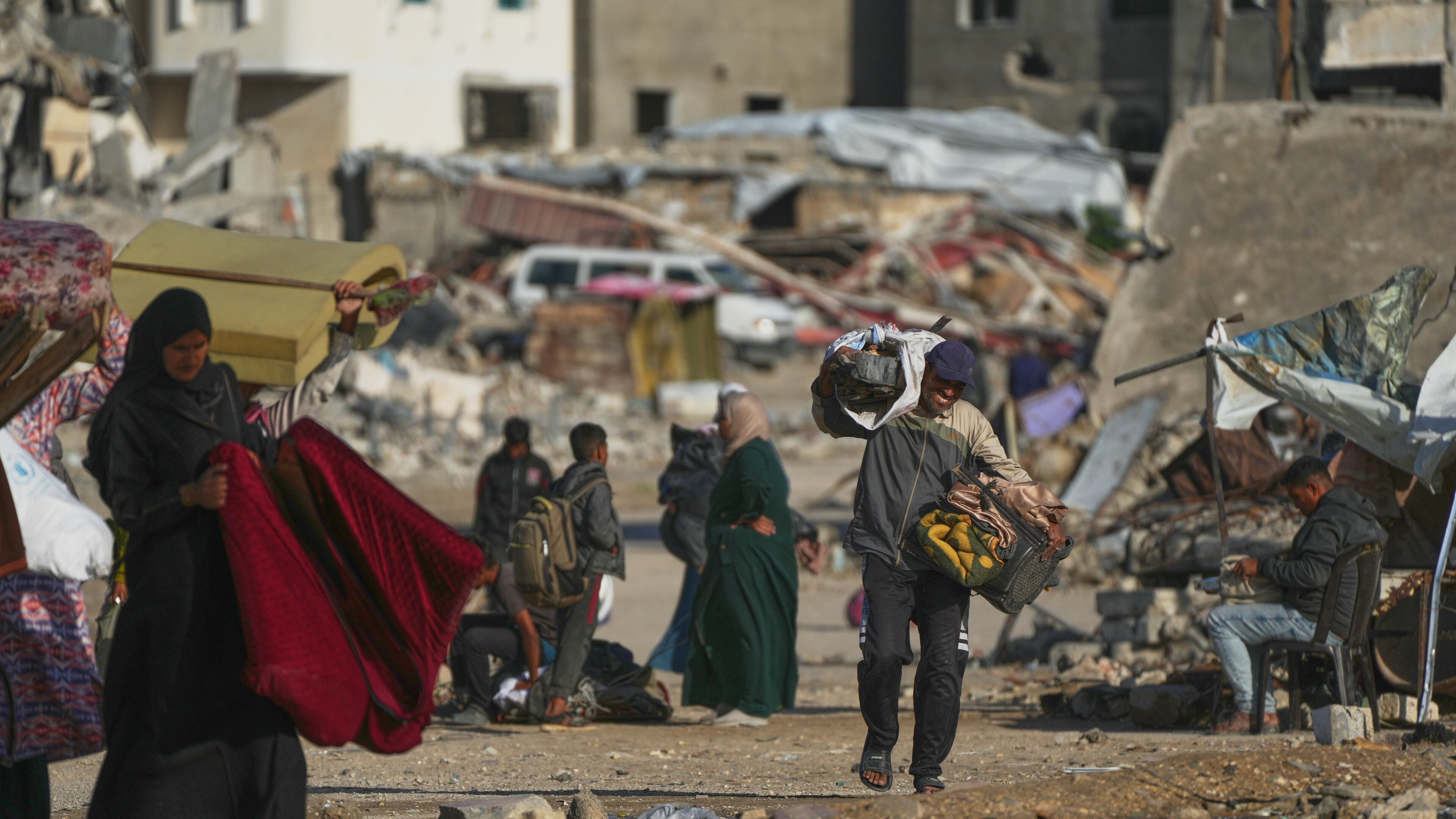 A man Palestinian man carries bags of firewood after collecting them from the rubbish in Khan Younis, southern Gaza Strip, on Saturday, Nov. 15, 2025.(AP Photo/Abdel Kareem Hana)