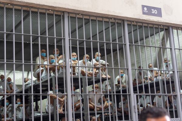 Prisoners look out of their cell as Homeland Security Secretary Kristi Noem tours the Terrorist Confinement Center in Tecoluca, El Salvador, Wednesday, March 26, 2025. (AP Photo/Alex Brandon)