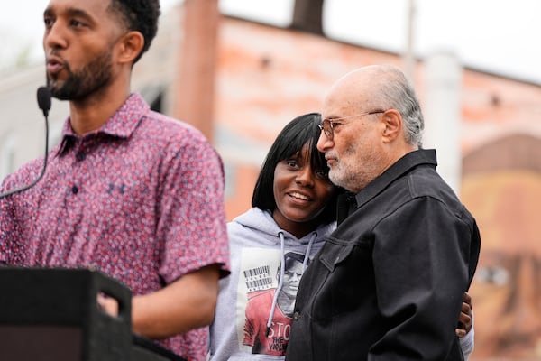 Fredricka Gray, twin sister of Freddie Gray, center, embraces William H. "Billy" Murphy, Jr. as Baltimore Mayor Brandon Scott, left, speaks at a memorial event commemorating the ten-year anniversary of the death of Freddie Gray, Saturday, April 19, 2025, in Baltimore. (AP Photo/Stephanie Scarbrough)
