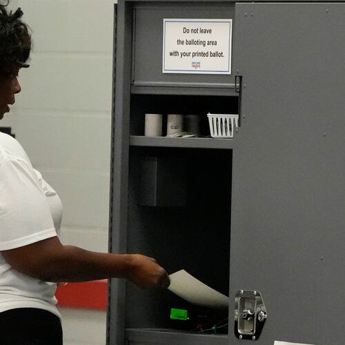 A woman places her paper ballot into a machine after voting in a runoff election at C.T. Martin Recreation Center, Tuesday, June 16, 2026, in Atlanta. (AP Photo/Mike Stewart)