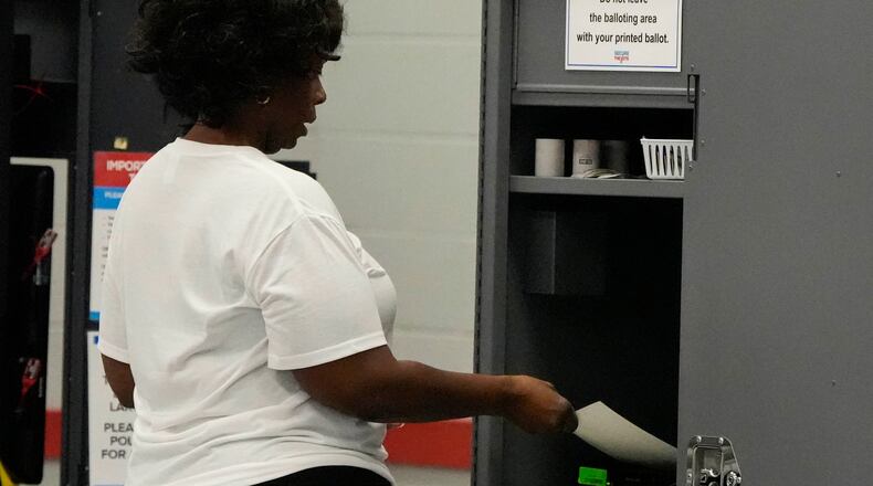 A woman places her paper ballot into a machine after voting in a runoff election at C.T. Martin Recreation Center, Tuesday, June 16, 2026, in Atlanta. (AP Photo/Mike Stewart)