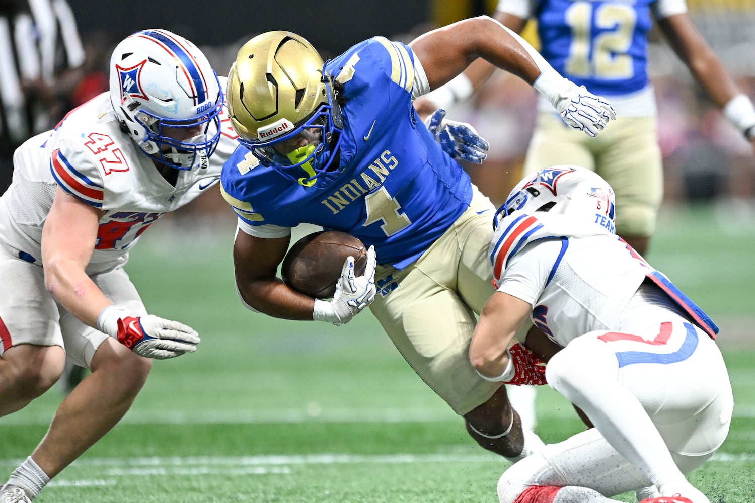 Walton defensive end Sam Nicholson (47) and free safety Sam Strickland (5) bring down McEachern running back Henry Mullen during the first half of the Corky Kell Classic  Saturday, August 16, 2025 at the Mercedes-Benz Stadium. (Daniel Varnado/For the Atlanta Journal-Constitution)