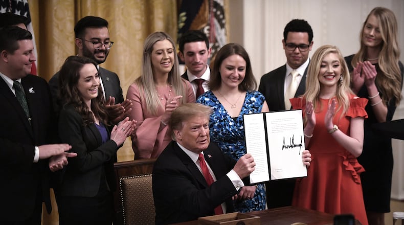President Donald Trump holds a signed executive order to require colleges and universities to “support free speech” on campus or risk loss of federal research funds, during an event in the East Room of the White House on Thursday, March 21, 2019. (Olivier Douliery/Abaca Press/TNS)