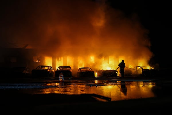 A rescue worker puts out a fire of cars destroyed by a Russian drone strike in Zaporizhzhia, Ukraine, on Wednesday, June 18, 2025. (AP Photo/Kateryna Klochko)