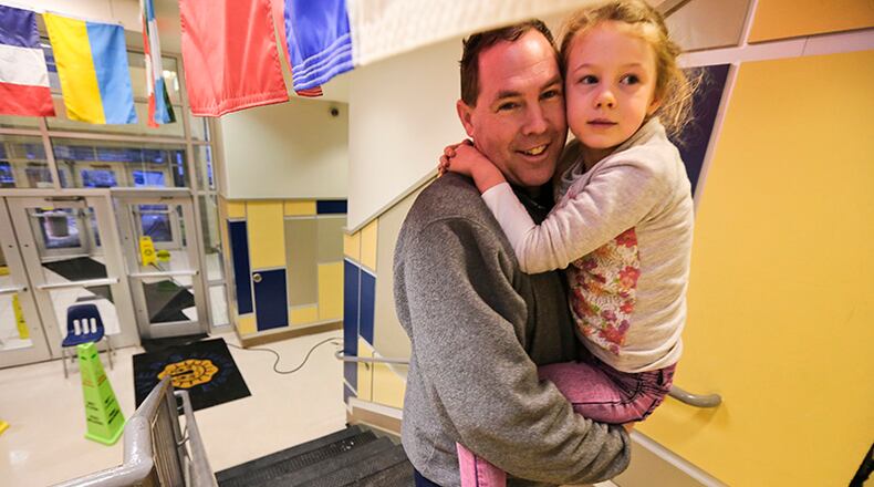 Mark Nilson walked six miles from his home to spend the night with his 5-year-old daughter, Elizabeth, a kindergartner. at E. Rivers Elementary in Atlanta. More than 100 schoolchildren and 35 staff members including some parents and bus drivers spent the night at the school. Two movies with popcorn was served after a pizza dinner from the cafeteria. Some parents were able to come during the night and retrieve their children. Some even walked.