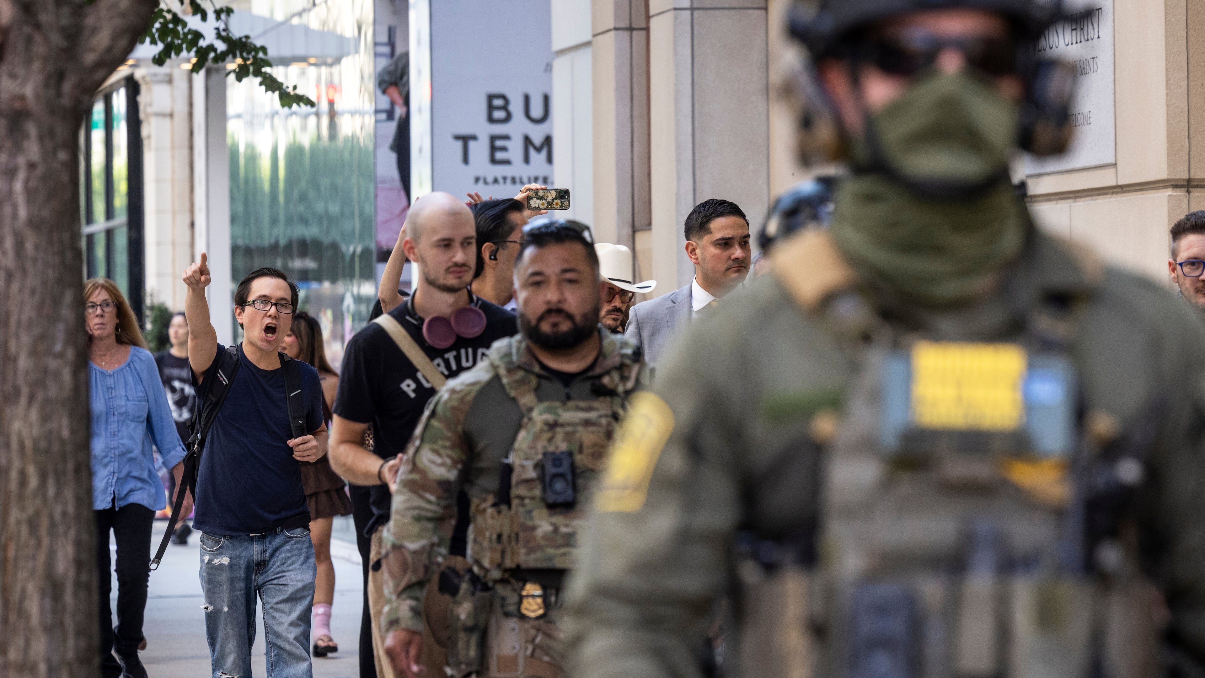 Pedestrians chant, "ICE go home!" as federal immigration agents walk along North Clark Street in the River North neighborhood, Sunday, Sept. 28, 2025, in Chicago. (Ashlee Rezin/Chicago Sun-Times via AP)