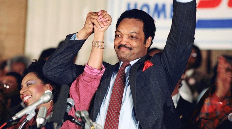 FILE - Democratic presidential hopeful Jesse Jackson with his wife, Jacqueline, salutes the cheering crowd at Operation Push in Chicago, March 10, 1988. (AP Photo/Fred Jewell, File)