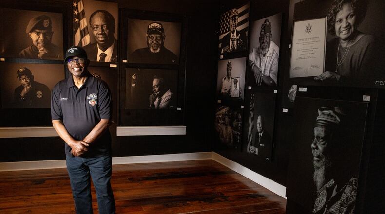 Vietnam Veteran Sgt. Johnny Miller poses for photographs in front of a series of portraits of Black Vietnam War veterans now on display at the Marietta History Center Tuesday, June 27, 2023. (Steve Schaefer/steve.schaefer@ajc.com)