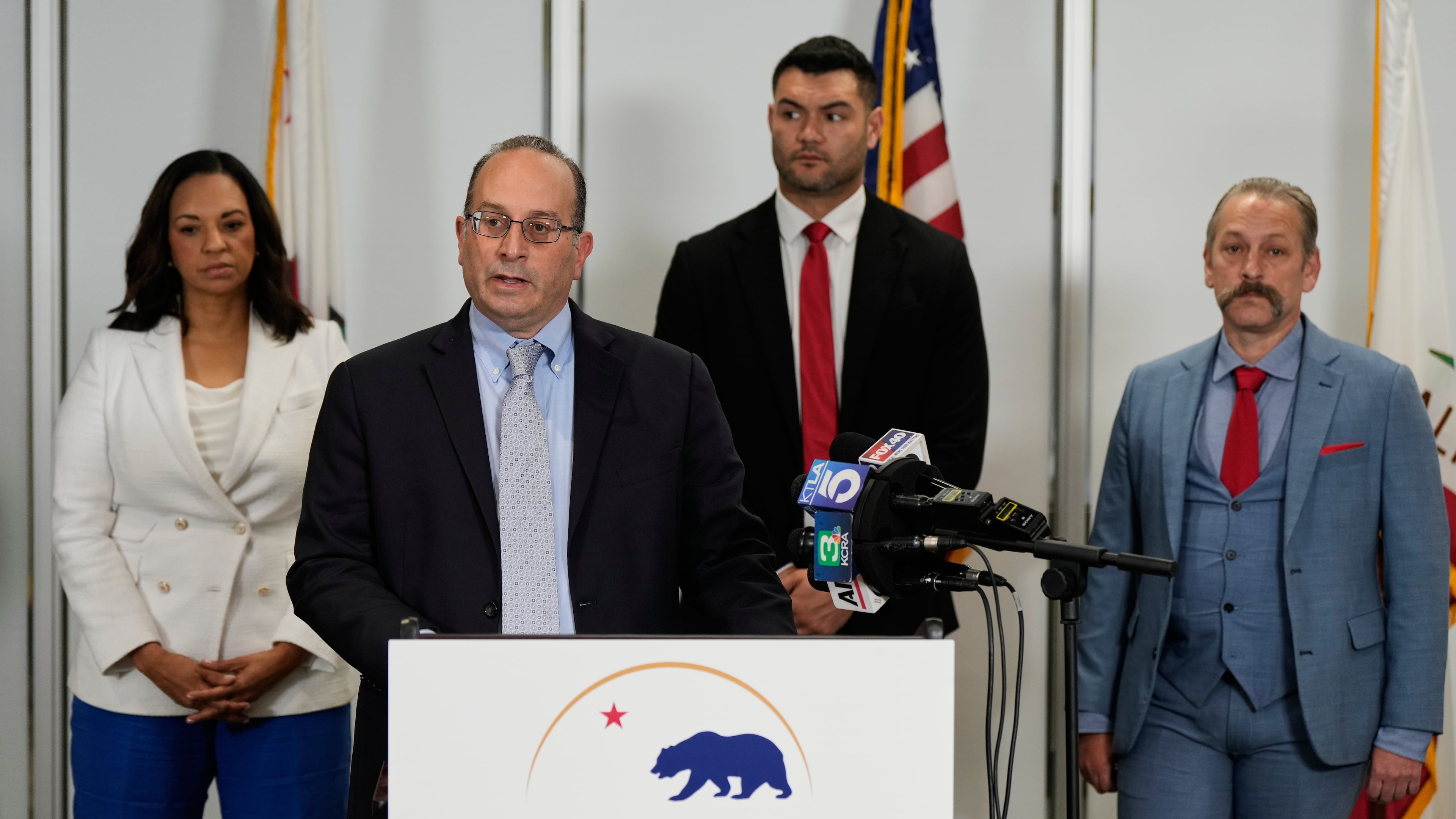 Dhillon Law Group partner Mike Columbo, second from left, speaks to reporters during a press conference announcing a federal lawsuit challenging Proposition 50, Wednesday, Nov. 5, 2025, in Sacramento, Calif. (AP Photo/Godofredo A. Vásquez)
