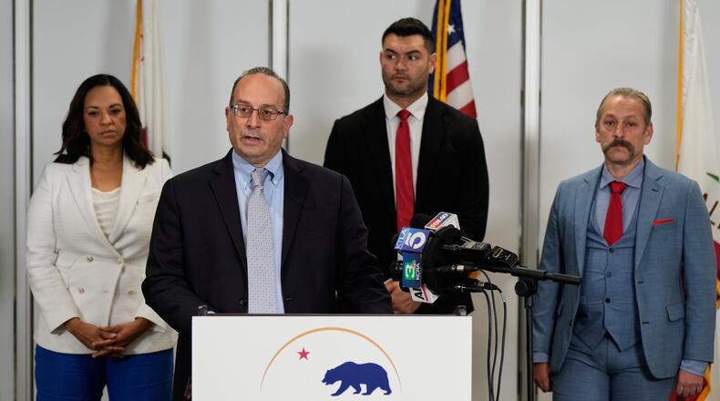 Dhillon Law Group partner Mike Columbo, second from left, speaks to reporters during a press conference announcing a federal lawsuit challenging Proposition 50, Wednesday, Nov. 5, 2025, in Sacramento, Calif. (AP Photo/Godofredo A. Vásquez)