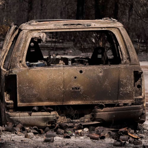 A burned vehicle sits near a destroyed home as the Brantley Highway 82 fire burns, Thursday, April 23, 2026, near Nahunta, Ga. (AP Photo/Mike Stewart)
