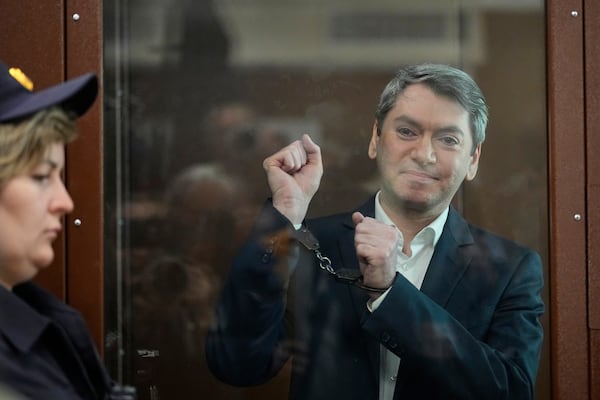 Grigory Melkonyants, co-chair of Russia's leading independent election monitoring group Golos looks at the media standing in a cage in a courtroom prior to a hearing in Basmanny district court in Moscow, Russia, Wednesday, May 14, 2025. (AP Photo/Alexander Zemlianichenko)