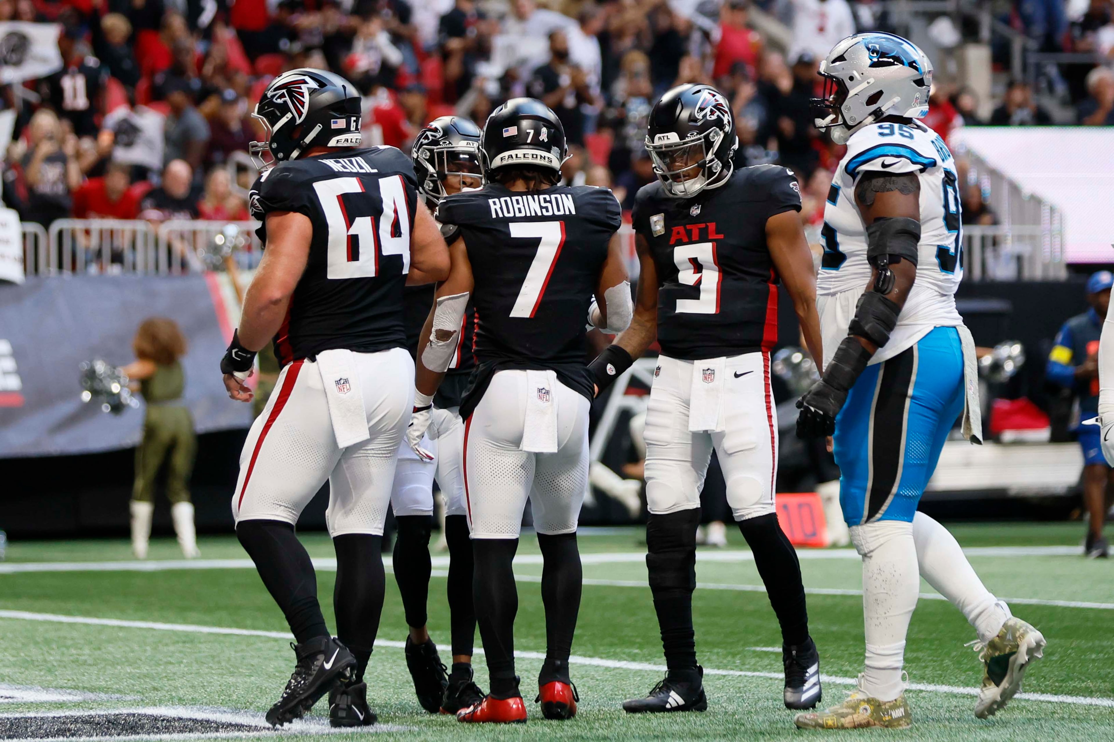 Atlanta Falcons quarterback Michael Penix Jr. (second from right) celebrates with Atlanta Falcons running back Bijan Robinson (second from left) after his second touchdown during the first half of an NFL game against the Carolina Panthers at Mercedes-Benz Stadium in Atlanta on Sunday, Nov. 16, 2025. (Miguel Martinez/AJC)