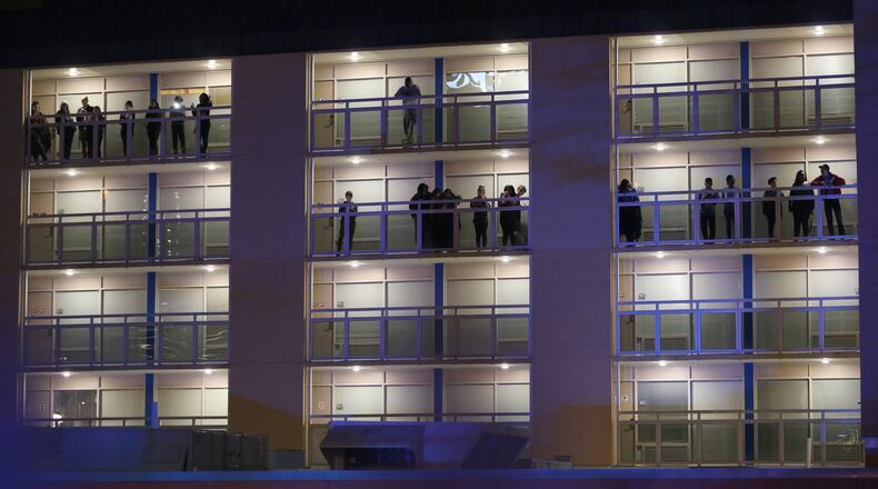 Students watch from the balconies of Georgia State University’s Piedmont North residence hall as police investigate a double shooting on the property Monday night, March 21, 2016. Ben Gray / bgray@ajc.com