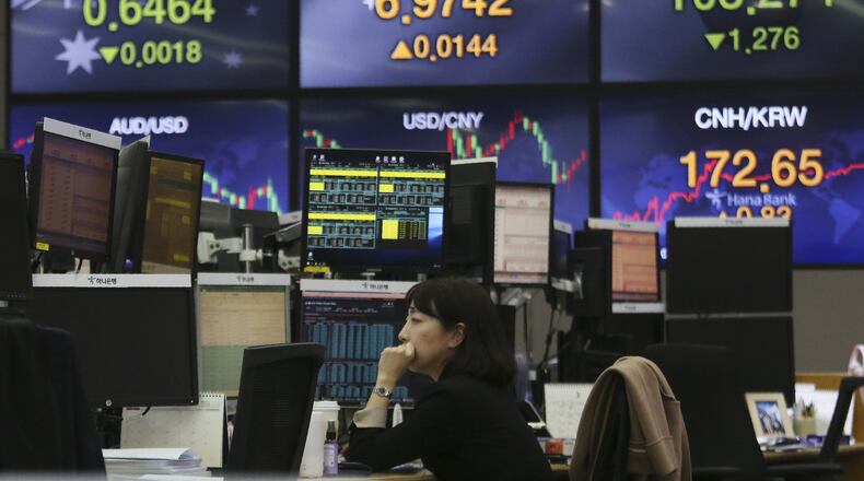 A currency trader watches monitors at the foreign exchange dealing room of the KEB Hana Bank headquarters in Seoul, South Korea, Thursday, March 12, 2020. Asian shares plunged Thursday after the World Health Organization declared a coronavirus pandemic and indexes sank deeply on Wall Street. (AP Photo/Ahn Young-joon)