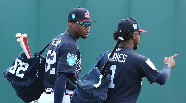 Ronald Acuna and Ozzie Albies head out with their gear early in spring training.