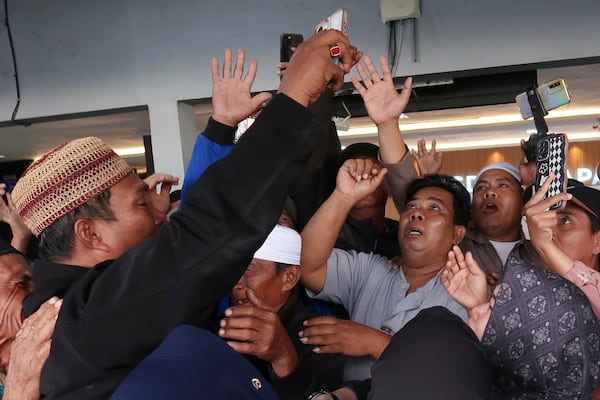 Relatives react as they have a video call with a survivor from a ferry that sank near the resort island of Bali, at Ketapang Port in Bayuwangi, East Java, Indonesia, Thursday, July 3, 2025. (AP Photo/Andur)