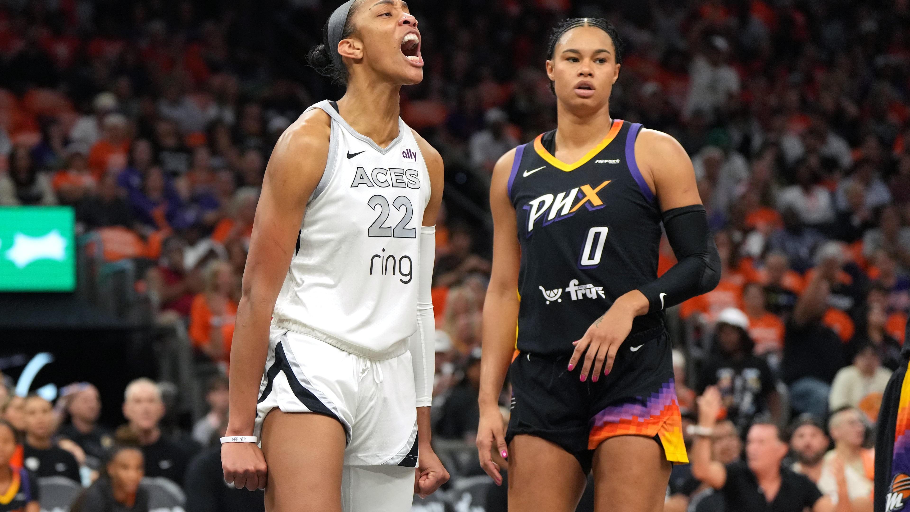 Las Vegas Aces center A'ja Wilson (22) reacts after scoring on Phoenix Mercury forward Satou Sabally during the first half of Game 3 of the WNBA basketball finals, Wednesday, Oct. 8, 2025, in Phoenix. (AP Photo/Rick Scuteri)