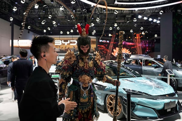 A man dressed as the character from Black Myth:Wukong promotes a special edition Han L model from BYD during the Shanghai auto show on Wednesday, April 23, 2025. (AP Photo/Ng Han Guan)