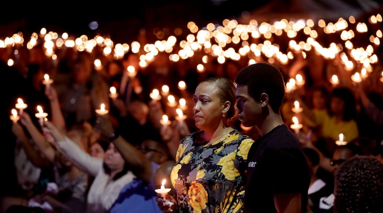 Veronica Hartfield, stands with her son, Ayzayah Hartfield during a candlelight vigil for her husband, Las Vegas police officer Charleston Hartfield, Thursday, Oct. 5, 2017, in Las Vegas. Hartfield was killed during the Sunday night shooting at the Route 91 Harvest country music festival. (AP Photo/Gregory Bull)