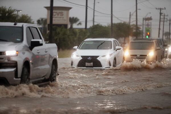 Vihicles drive along Jackson road during a downpour on Thursday, March 27, 2025, in Edinburg, Texas. (Joel Martinez /The Monitor via AP)