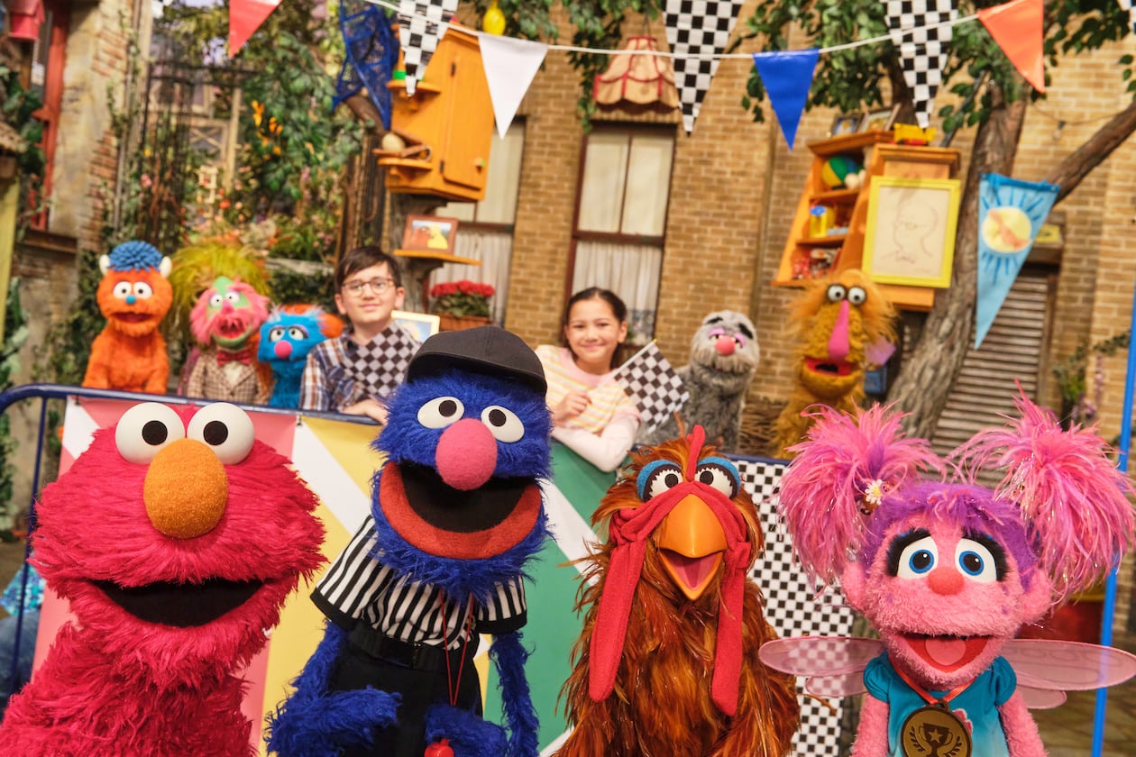 This image released by Sesame Workshop shows muppet characters Elmo, left, Grover, second left, and Abby, right, from the "Sesame Street" episode "Elmo Runs the Race." (Zach Hyman/Sesame Workshop via AP)