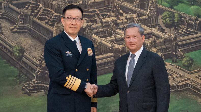 In this photo released by Agence Kampuchea Press (AKP), Chinese Defense Minister Dong Jun, left, shakes hands with Cambodian Prime Minister Hun Manet prior to a meeting at Peace Palace in Phnom Penh, Cambodia, Wednesday, April 22, 2026. (Heng Sinith/AKP via AP)