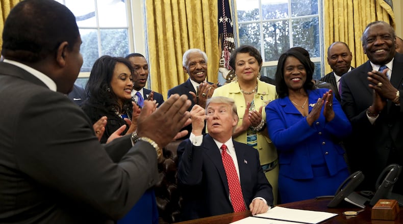President Donald Trump gives a pen after signing the HBCU Executive Order to support Black Colleges and Universities in the Oval Office of the White House in February 2017. (Photo by Aude Guerrucci-Pool/Getty Images)
