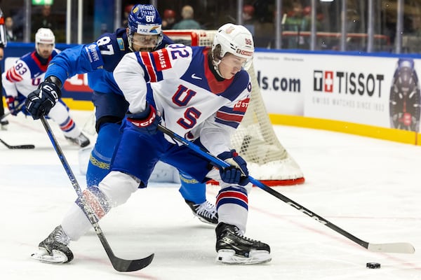 Kazakhstan's defender Adil Beketayev, left, vies for the puck with USA's forward Logan Cooley, right, during the IIHF 2025 World Championship preliminary round group B game between Kazakhstan and USA, at the Jyske Bank Boxen, in Herning, Denmark, Sunday, May 18, 2025. (Salvatore Di Nolfi/Keystone via AP)