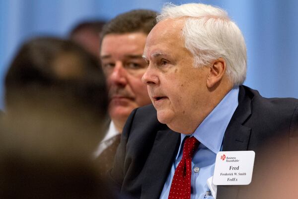 FILE - FedEx founder and CEO Fred Smith asks a question of President Barack Obama during the president's meeting with leading CEOs to discuss ways to promote the economy and create jobs during his last two years in office, Wednesday, Dec. 3, 2014, at the Business Roundtable Headquarters in Washington. (AP Photo/Jacquelyn Martin, File)