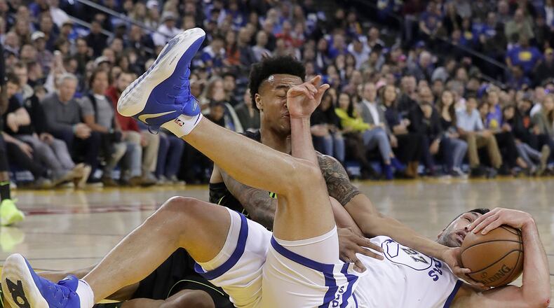 Golden State Warriors center Zaza Pachulia, right, grabs the ball in front of Atlanta Hawks forward John Collins during the first half of an NBA basketball game in Oakland, Calif., Friday, March 23, 2018. (AP Photo/Jeff Chiu)
