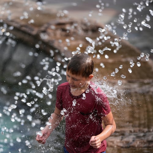 A boy cools himself off in a fountain on a hot summer day in Moscow, Thursday, Aug. 6, 2026. (AP Photo/Pavel Bednyakov)