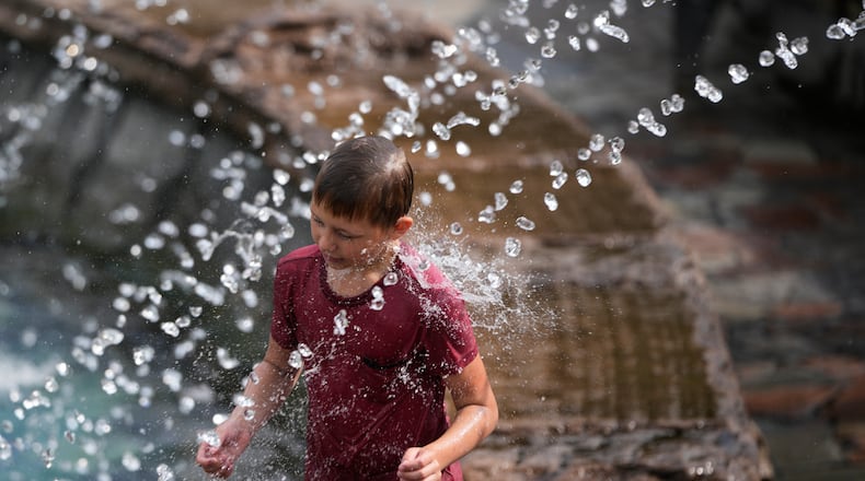 A boy cools himself off in a fountain on a hot summer day in Moscow, Thursday, Aug. 6, 2026. (AP Photo/Pavel Bednyakov)