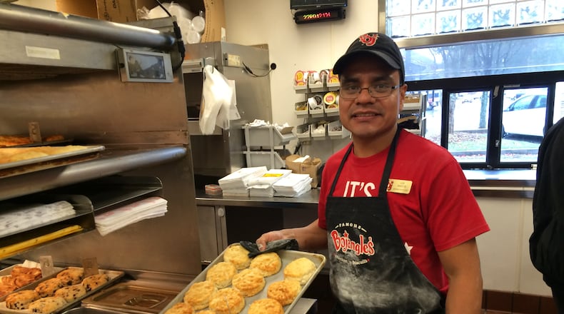 Bojangles employee Luis Santos holds a tray of biscuits. Santos is competing in the finals of the company's master biscuit-making competition. / Ligaya Figueras