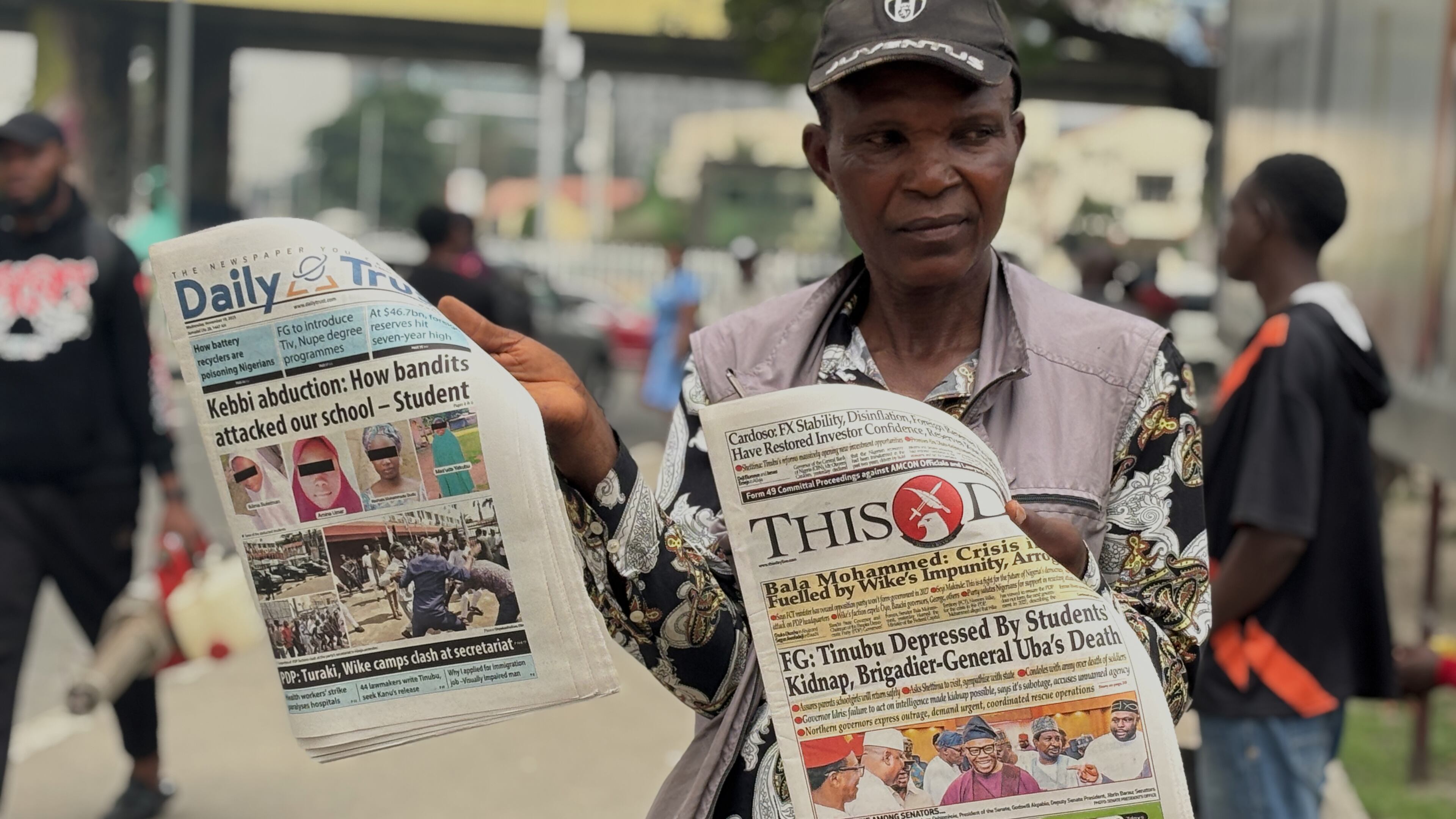 A vendor display local newspapers on the street of Lagos with headlines of the Government Girls Comprehensive Secondary School, where gunmen on Monday attacked the school dormitory, abducted schoolgirls, in Kebbi Nigeria, Wednesday, Nov. 19 2025. (AP Photo/Sunday Alamba )